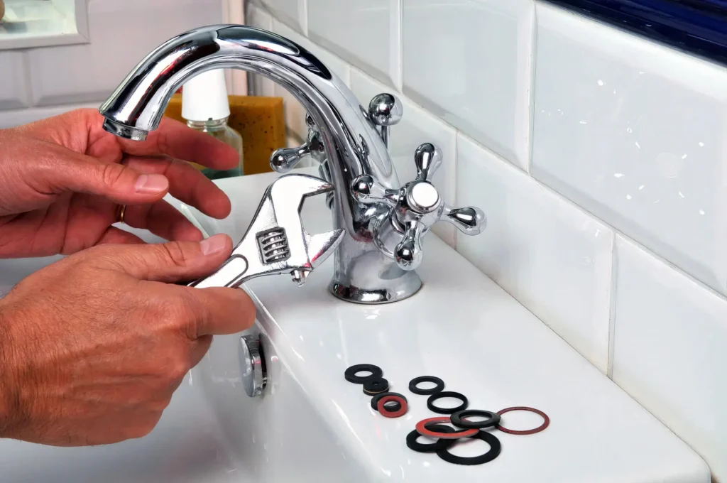 Plumber performing maintenance on a bathroom faucet in Englewood