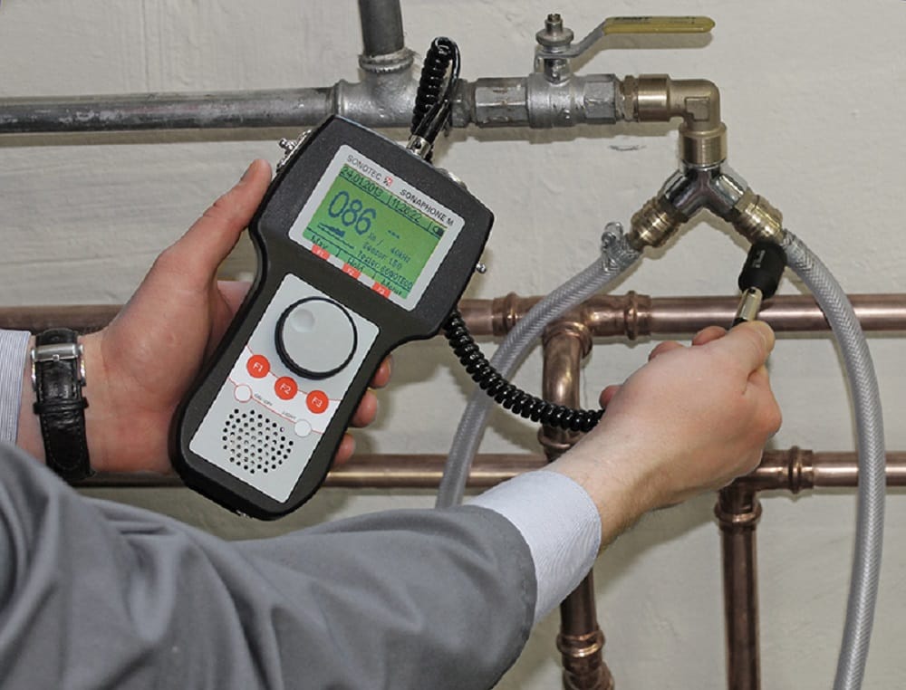 Plumber testing pipes with electronic leak detection equipment in Englewood
