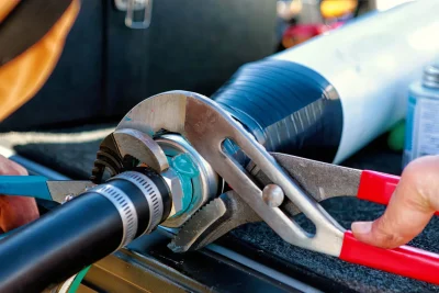 Technician tightening an industrial pipe connection in Englewood